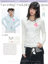 BETWEENAND「Music Box Melody」Spring: a loose-long-sleeved T-shirt with a V-neck and various prints, worn while working