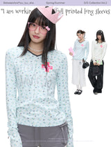BETWEENAND「Music Box Melody」Spring: a loose-long-sleeved T-shirt with a V-neck and various prints, worn while working