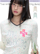 BETWEENAND「Music Box Melody」Spring: a loose-long-sleeved T-shirt with a V-neck and various prints, worn while working